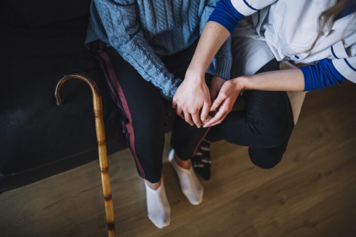 infortunio nel lavoro domestico: anziano e badante che si tengono per mano